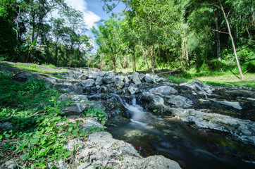 A small little waterfall falling on a small lake in Thailand