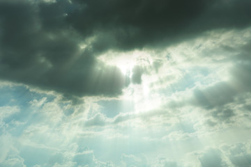 Nature background.The sun shines down from the sky, where the black cloud is covered.
