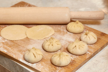 Fototapeta na wymiar Homemade raw khinkali dumplings on wooden board