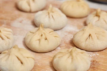 Fototapeta na wymiar Homemade raw khinkali dumplings on wooden board