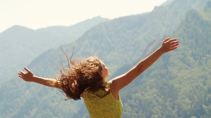 Beautiful woman standing on top of mountain and stretching out hands - Powered by Adobe
