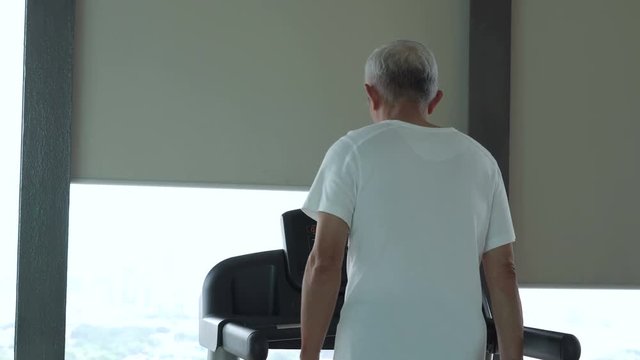Asian senior man running on a treadmill at the gym healthy lifestyle exercise