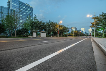 empty asphalt road front of modern buildings at dusk
