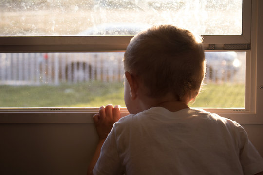 Boy Looking Out Window Door