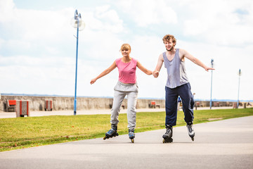 Fototapeta premium Active young people friends rollerskating outdoor.