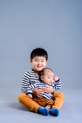 赤ちゃんを抱いている男の子 スタジオポートレート