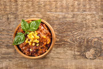 Chili con carne in bowl on wooden table