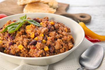 Plate with delicious chili con carne on table