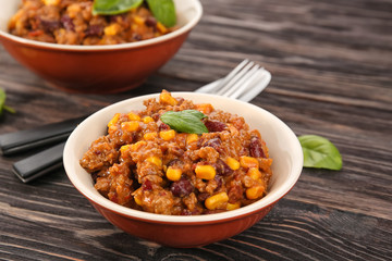 Bowls with delicious chili con carne on table