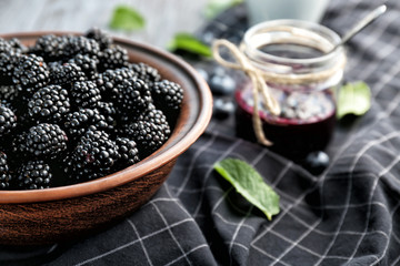 Bowl with delicious ripe blackberries on table, closeup