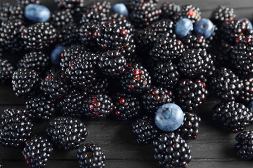 Closeup of ripe blackberries and blueberries on wooden background