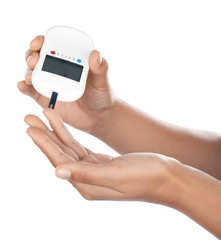 Woman testing glucose level with digital glucometer on white background. Diabetes concept