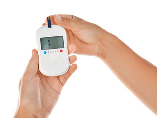 Woman testing glucose level with digital glucometer on white background. Diabetes concept