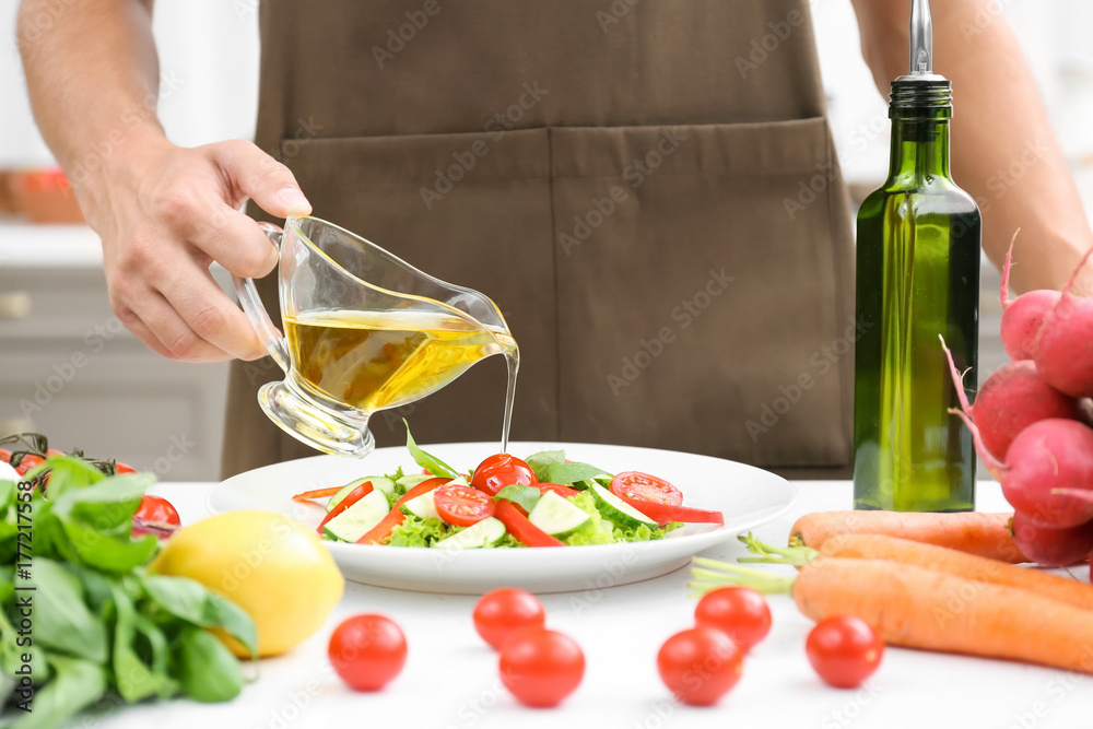 Canvas Prints man pouring cooking oil onto vegetable salad in kitchen