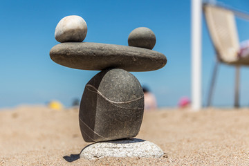 Fototapeta na wymiar Symbol The scales are made of stones of various shapes on the beach. Balance of stone.