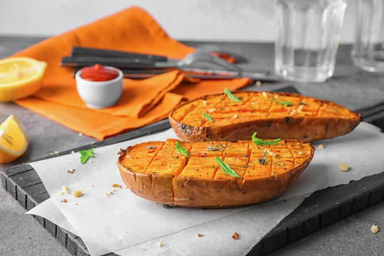 Cutting board with baked sweet potato on table