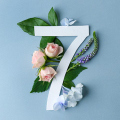 Beautiful floral composition with number seven made of paper on color background
