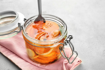 Jar with delicious marinated salmon on table