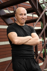 Bald man standing on stairs outdoors