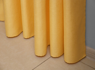 Beautiful yellow curtains indoors, closeup