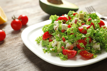 Plate with delicious goji berry salad on wooden background, closeup