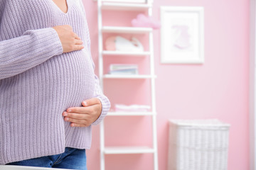 Pregnant woman standing in baby's room