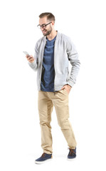 Fototapeta premium Attractive young man with smartphone on white background
