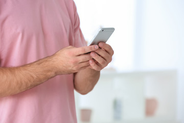 Man holding smartphone indoors
