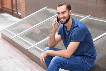 Fototapeta premium Man with smartphone on city street