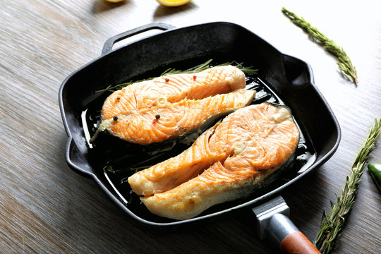 Grill pan with delicious salmon steaks on table