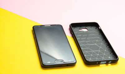 Smartphone and protective case on a yellow background. Protect your smartphone when it crashes.