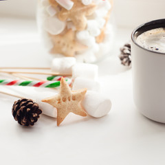 Xmas still-life. A cup of strong tea or coffee on the New Year's table. Many Christmas decorations and hot warming drink on a wooden background.