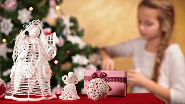 Girl decorating christmas tree - slowly refocusing to foreground decorations
