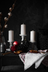 Autumn decor of a table with a white candles, fruits and Viennese wafers