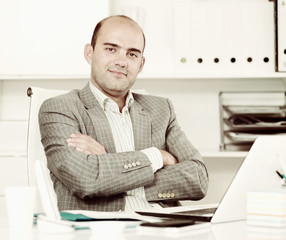 Obraz premium Worker drinking water and working at the laptop