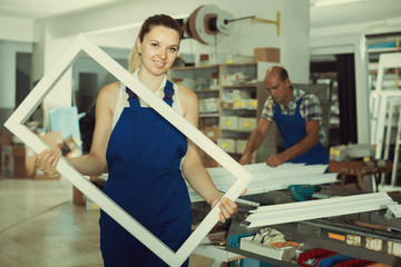 girl in workwear with window frame from pvc profile standing in