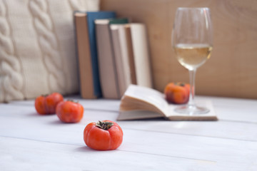 Still life interior details, glass of wine, opened book, pillow. Lazy winter weekend, readiing concept