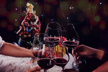 Christmas or New Year Celebration people hands with crystal glasses full of champagne near the Christmas tree and space for your text.