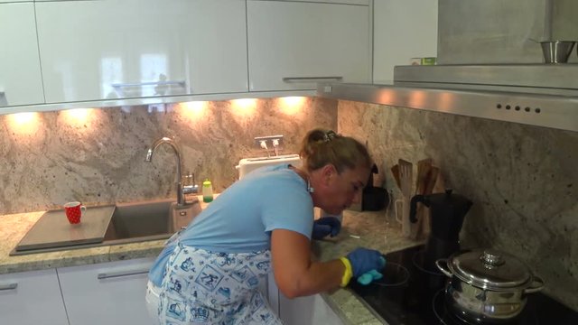 Obsessed housewife cleaning kitchen
