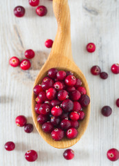 fresh cranberries on white wooden surface