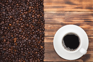 Coffee cup and beans on a rustic background