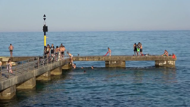 Cala Millor Mallorca Spain: Children and teenagers playing on a pier in the sea