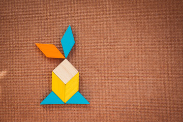Tangram puzzle shape on wooden texture background, use for education concept - Vintage filter