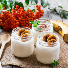 Yogurt with banana on a wooden table. Healthy breakfast.