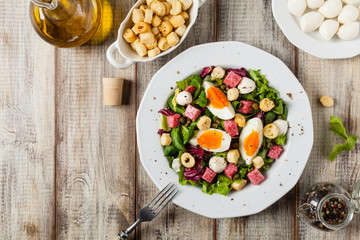 Delicious Italian salad with salami, egg, crostini and mozzarella.