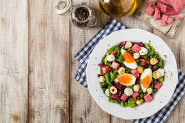 Delicious Italian salad with salami, egg, crostini and mozzarella.