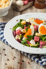Delicious Italian salad with salami, egg, crostini and mozzarella.