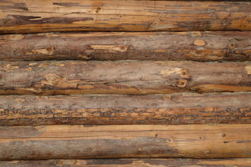 Hewed wall of modern log house from outside, wooden surface