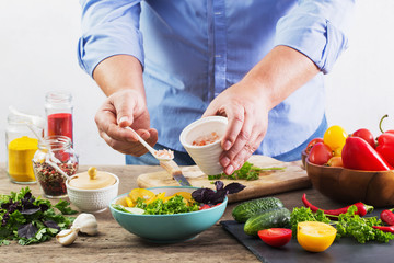 Obraz na płótnie Canvas man cooking a vegetarian salad