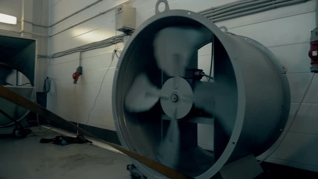 Fan blades spinning in car auto service close up. Stand for measuring car power